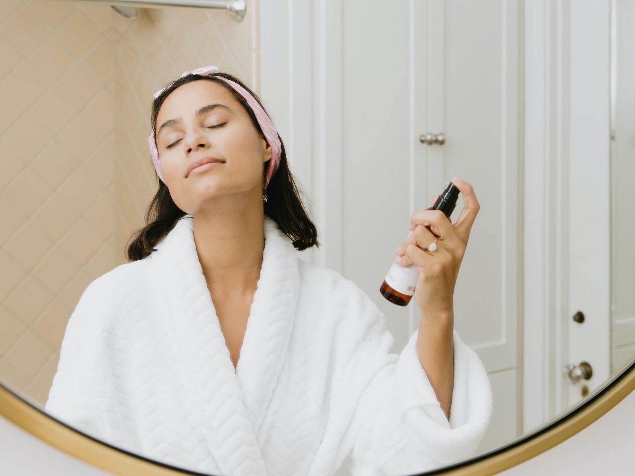 image of woman using spray product on face